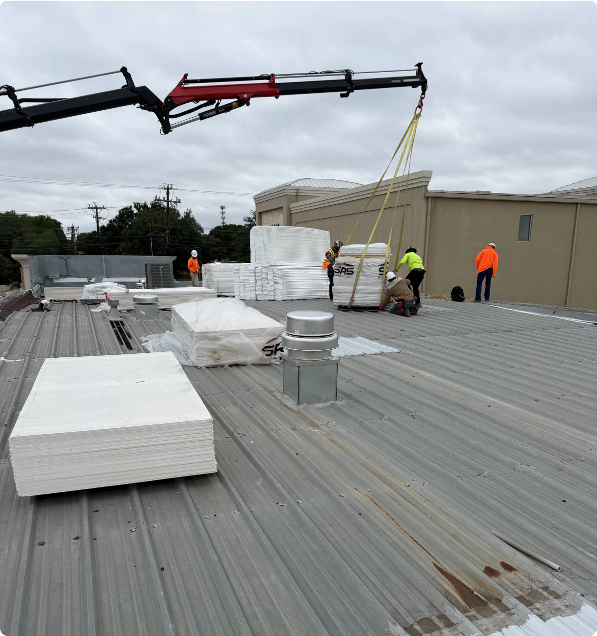 TMS Roofing crew installing materials on a commercial metal roof